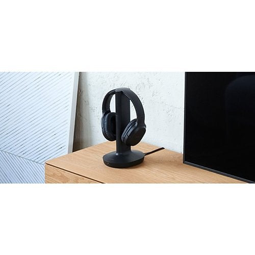 Sony Headphones WH-RF400 Wireless Mounted on a stand in a room on a table next to a TV Screen