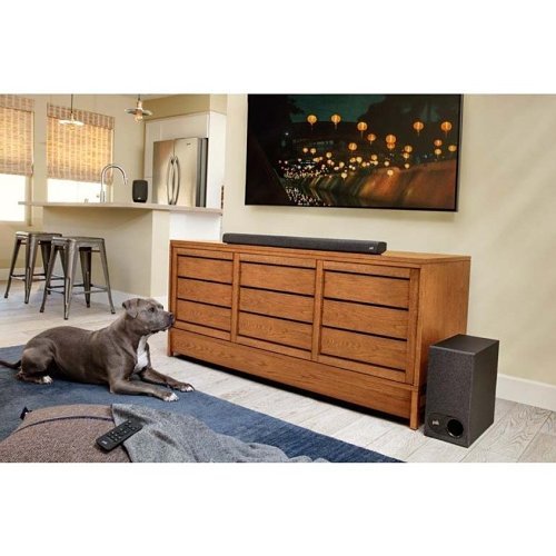 Polk Audio SIGNA S3 Slim Bluetooth Sound Bar with Wireless Sub in a living room with a dog staring at the theater system