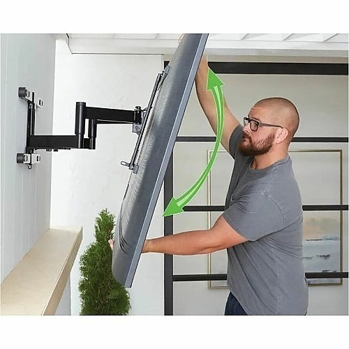 Sanus VODLF125-B2 Outdoor Full Motion TV Wall Mount 40–85 Inch
Man adjusting a large flat-screen TV on a wall mount in a modern living room.